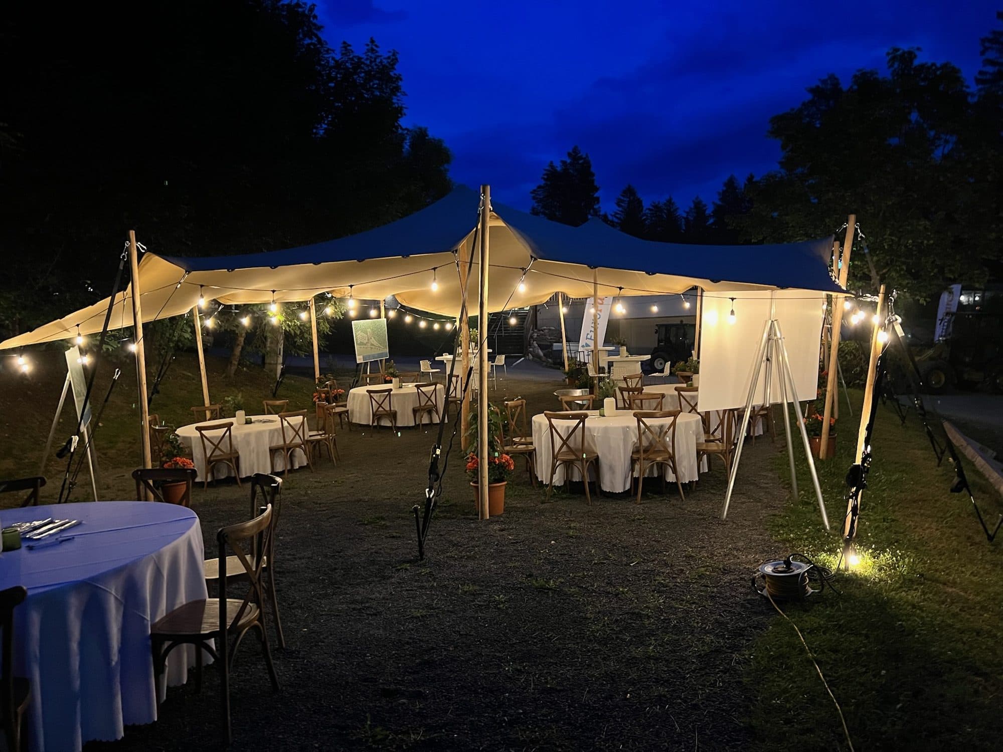 Bruiloft onder stretchtent met gedekte tafels en prikverlichting