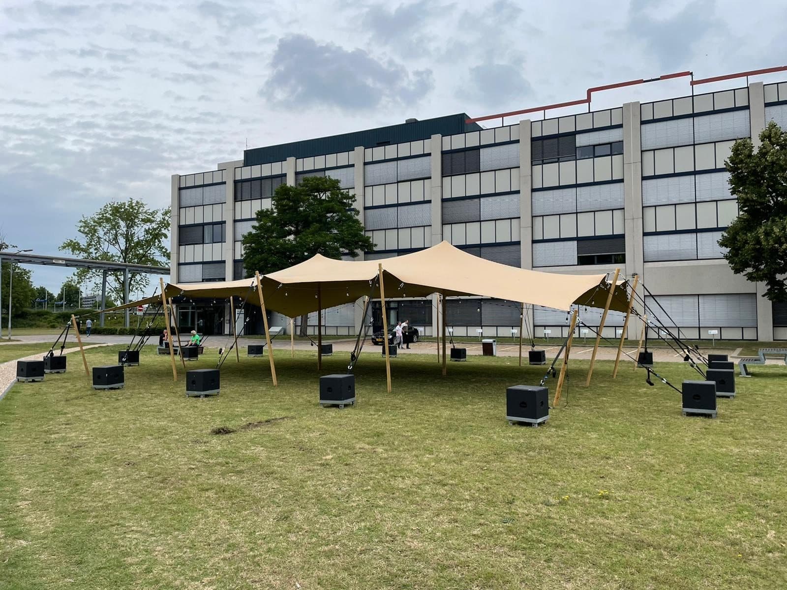 Stretchtent op een grasveld met gemeentelijke omgeving op de achtergrond
