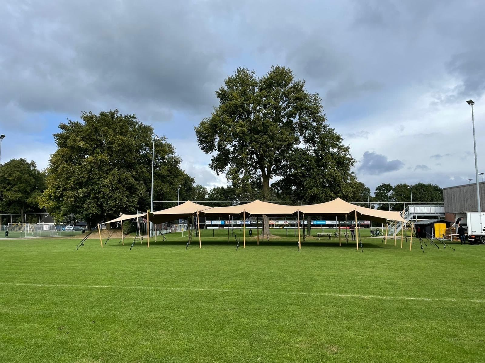 Lange stretchtent-opstelling op een grasveld