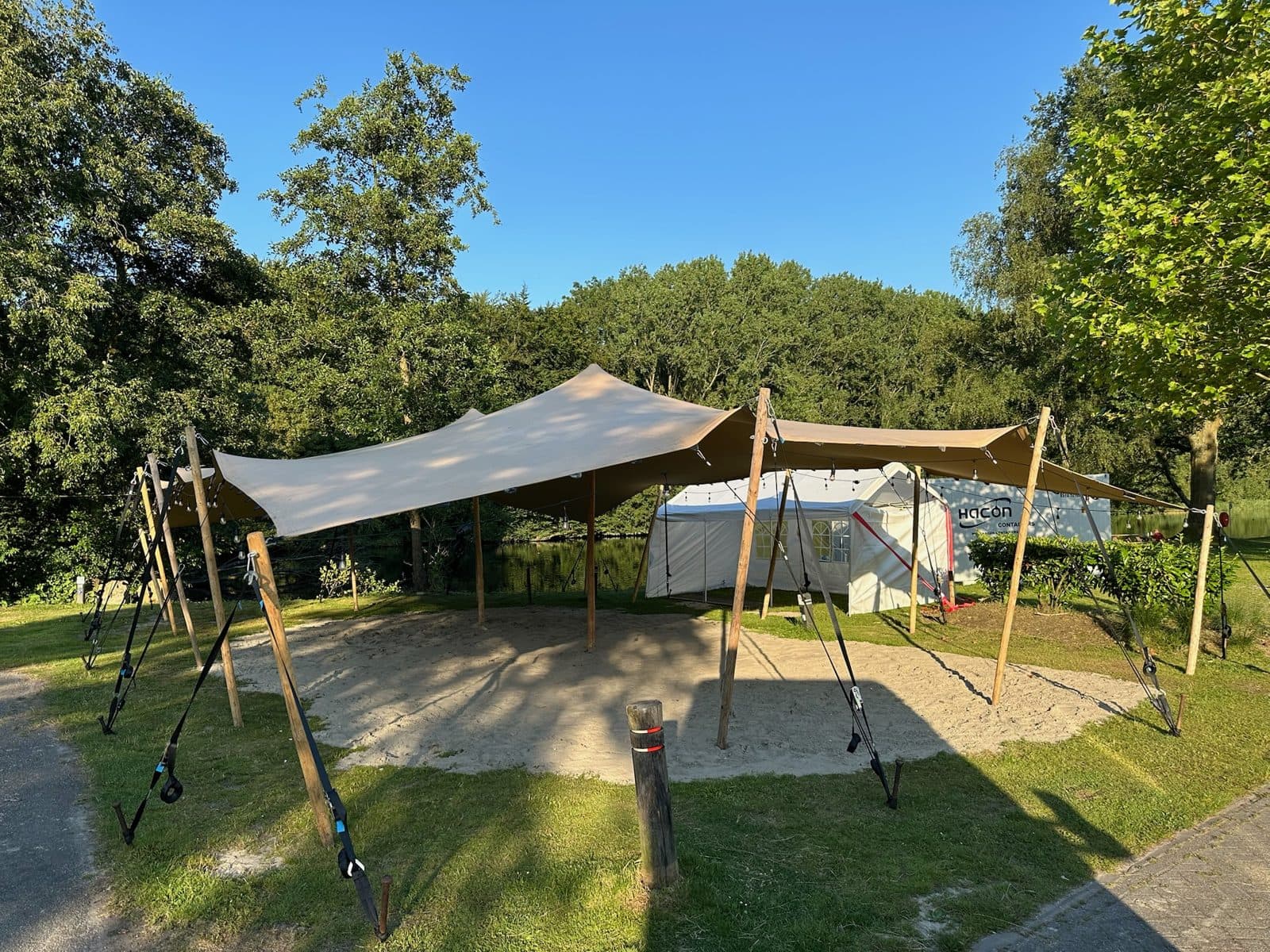 Stretchtent op een grasveld omringd door bomen