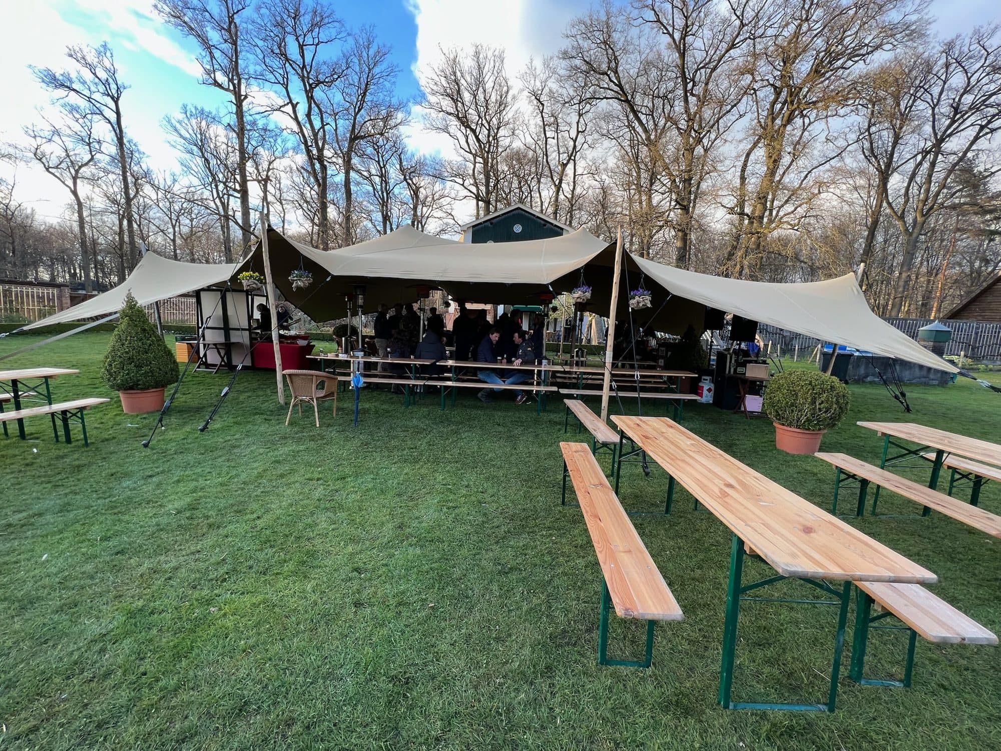 Stretchtent in een tuin met biertafels tijdens een feest